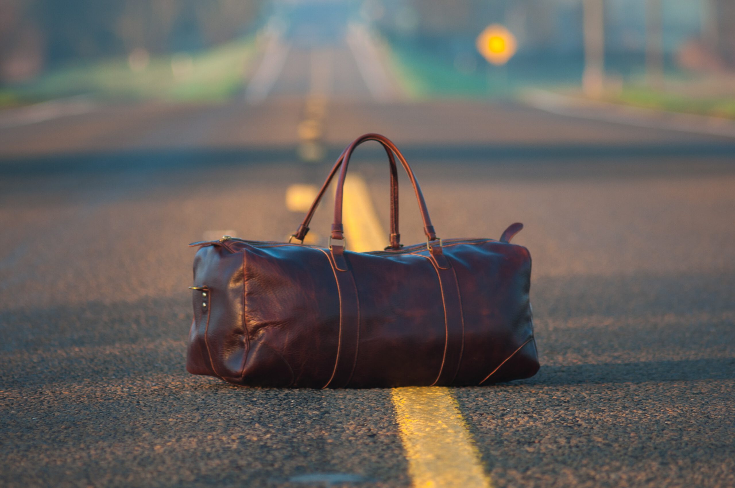 Leather duffel bag on the middle of a highway